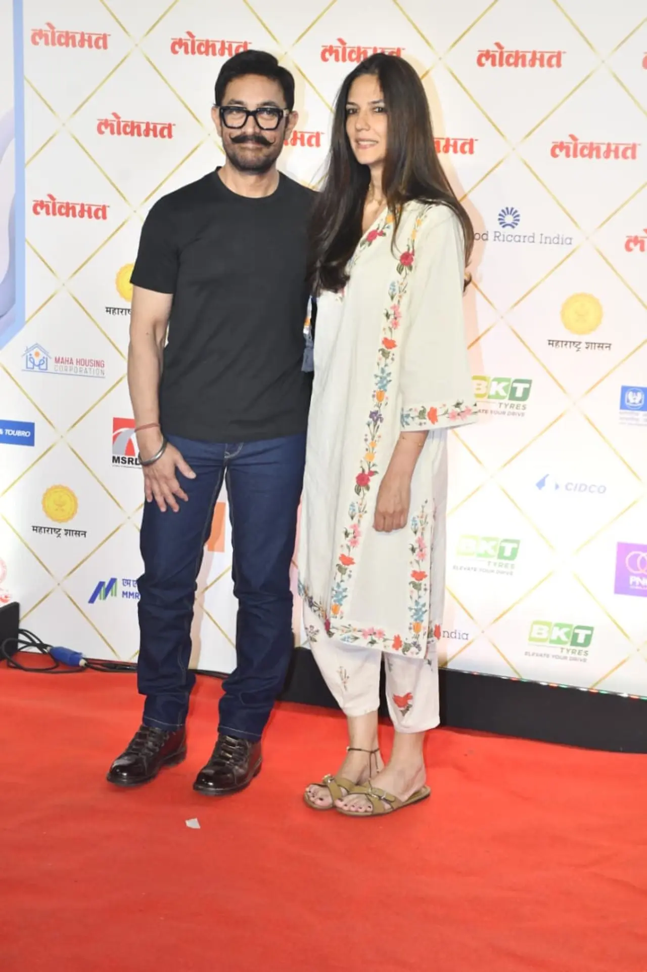 Aamir Khan was seen with Gauri Spratt at an event, who looked graceful in a white ethnic ensemble. Aamir kept it casual yet stylish in a black T-shirt paired with classic denim.